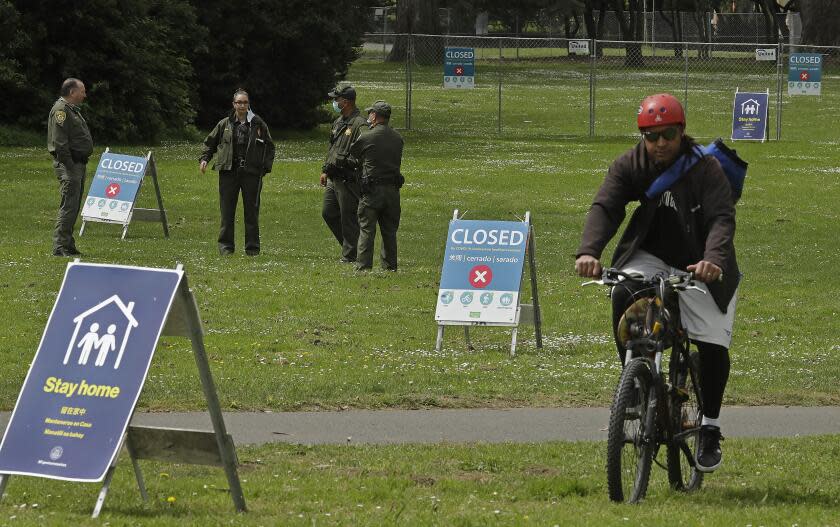 San Francisco Park Rangers guard an entrance that leads to Hippie Hill due to COVID-19 concerns on Monday, April 20, 2020, at Golden Gate Park in San Francisco. People annually gather on April 20, 4/20, to smoke marijuana on Hippie Hill. (AP Photo/Ben Margot)