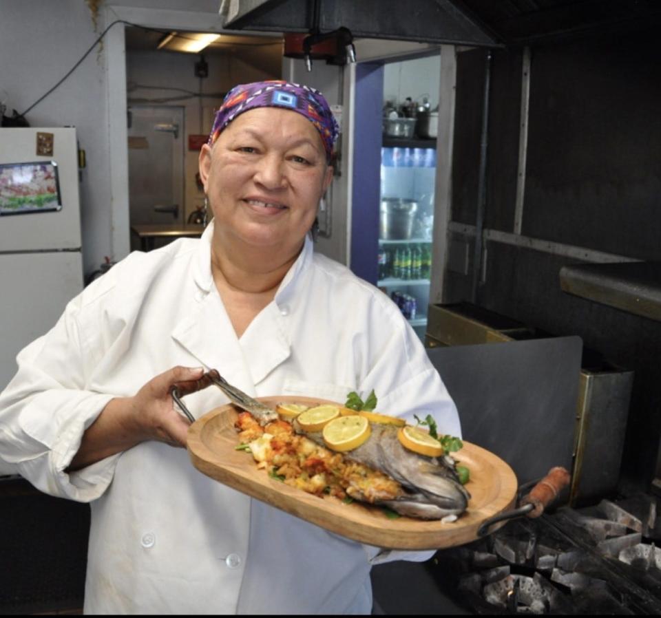 Chef Sherry Pocknett with a platter of her food at Sly Fox Den Too in Charlestown.