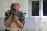 Alberto Gogu wipes sweat off his forehead after clearing debris in his courtyard