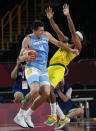 Argentina's Gabriel Deck (14) collides with Australia's Patty Mills (5) as he drives to the basket during a men's basketball quarterfinal round game at the 2020 Summer Olympics, Tuesday, Aug. 3, 2021, in Saitama, Japan. (AP Photo/Eric Gay)