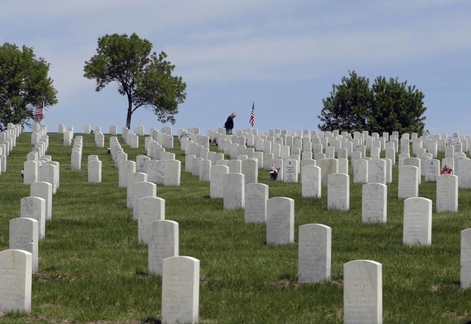 A man stands alone amidst the headstones at Fort Snelling National Cemetery, Friday, May 24, 2013 in Minneapolis, as visitors got an early start to the Memorial Day weekend. (AP Photo/Jim Mone) ORG XMIT: MP101