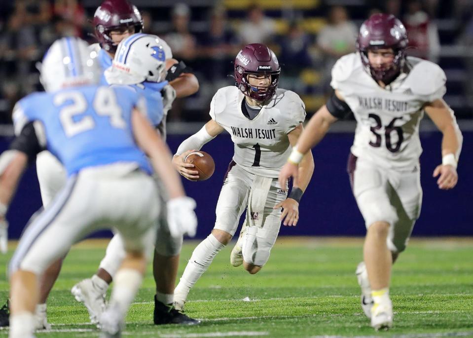 Walsh Jesuit quarterback Ryan Kerscher rushes for yards during the second half of a high school football game against Benedictine, Saturday, Aug. 20, 2022, in Euclid, Ohio.