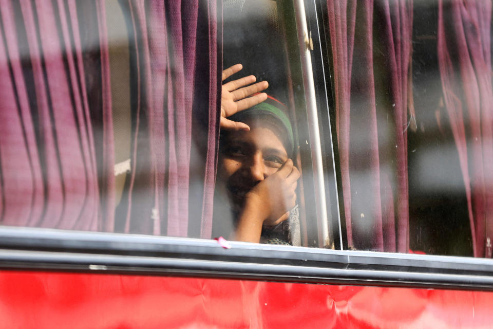 An Afghan girl waves from the bus window as she is being repatriated to Afghanistan, along with her family, who according to police were undocumented, in Karachi, Pakistan, on Nov. 2, 2023.  / Credit: AKHTAR SOOMRO / REUTERS