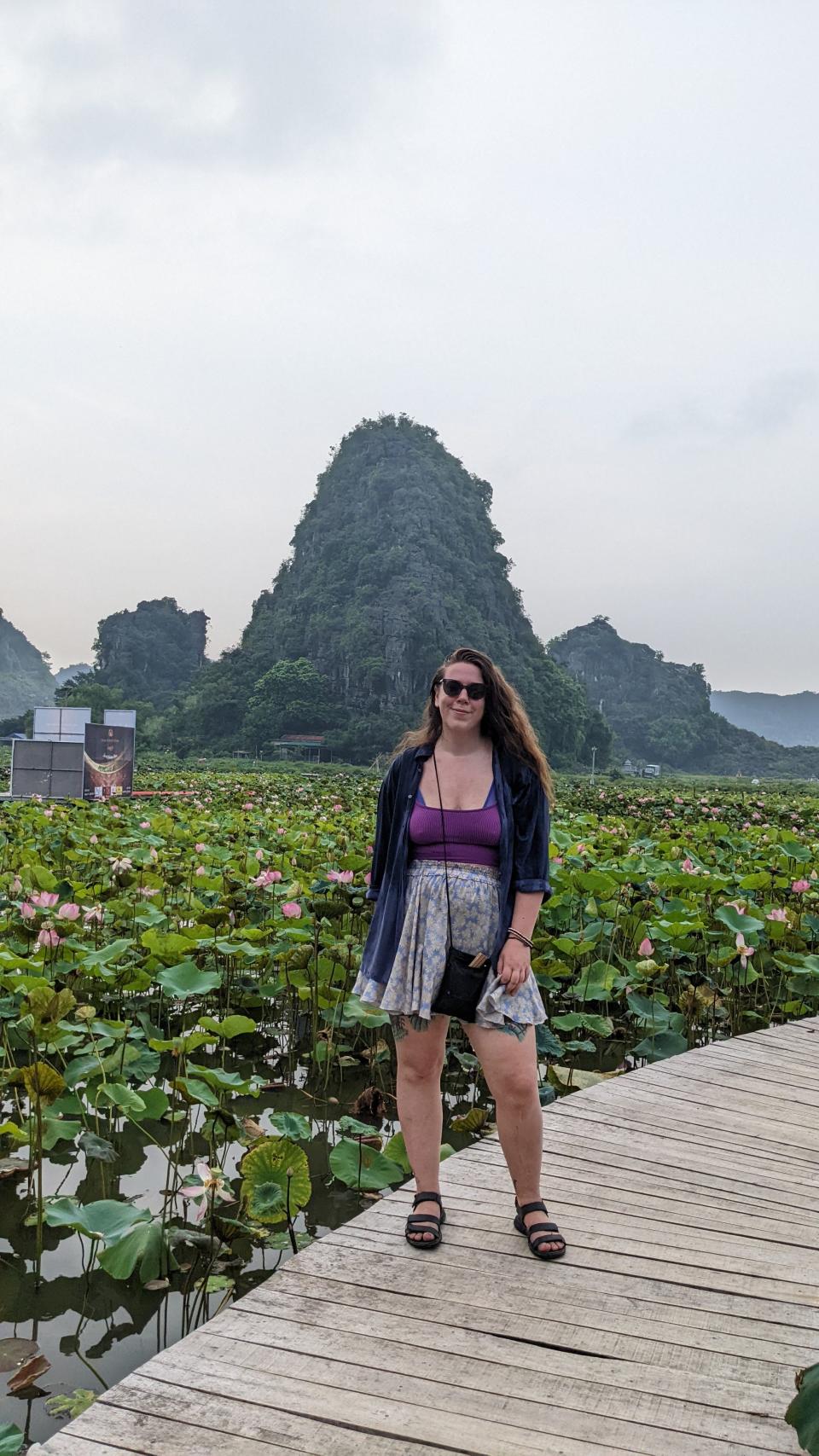 A woman posing in a scenic spot in Southeast Asia.