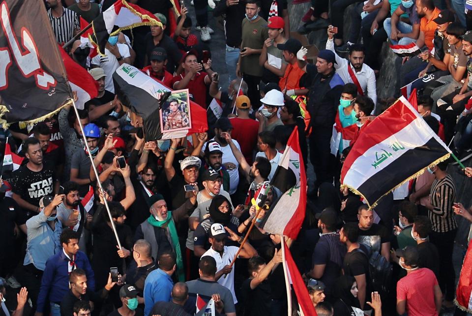 In this Thursday, Oct. 31, 2019 photo, mourners and protesters carry the flag-draped coffin of Mohammed Sadiq during his funeral during a demonstration at Tahrir Square in Baghdad, Iraq. Sadiq was killed while participating in the anti-government ongoing protests, his family said. (AP Photo/Hadi Mizban)