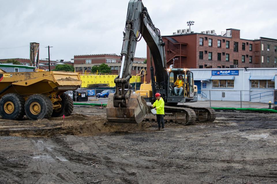 Field scientist Matthew Gallup scoops dirt taken from a pit by an excavator to test it for contaminants during environmental remediation of the Summer Street site where Crossroads Rhode Island is building 176 apartments.   [Wheeler Cowperthwaite/Providence Journal]