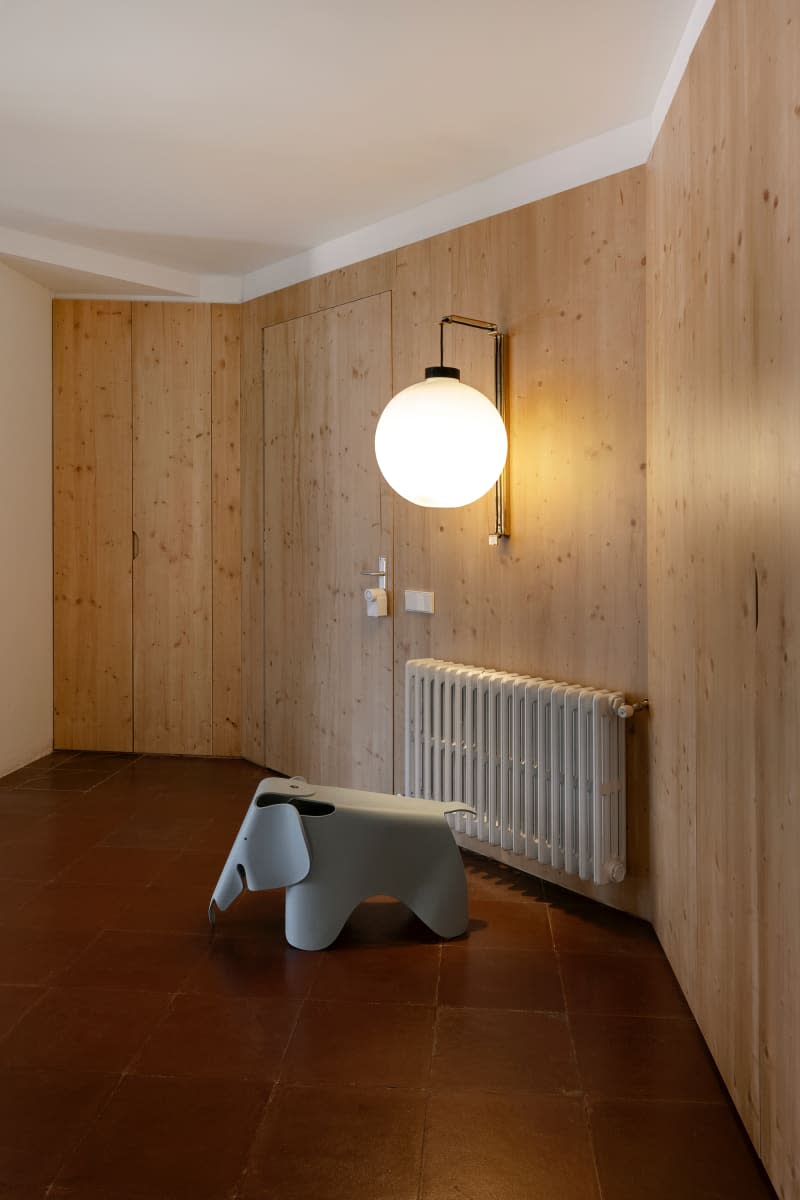 Large sconce on wood paneled walls.