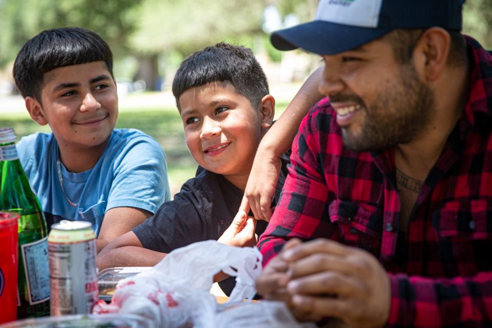 Andres Doria, 12, (from left) Seth Doria, 9, and their father Jamie Martinez, have a family picnic at Memorial Park in Uvalde, Texas, on May 25, 2022. Martinez removed his son Seth from Robb Elementary a couple hours before a gunman killed 21 people, including children.