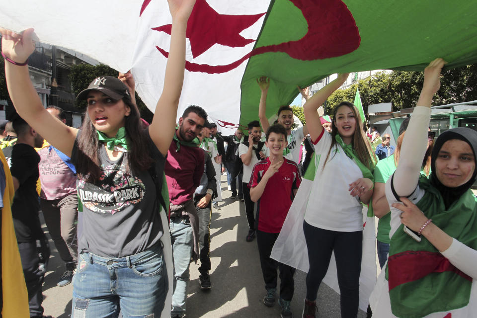 Demonstrators carry a giant Algerian flag during a protest in Algiers, Friday, April 26, 2019. Algerians are massing for a 10th week of protests against their country's ruling class, calling for the ex-president's brother to be put on trial. (AP Photo/Fateh Guidoum)