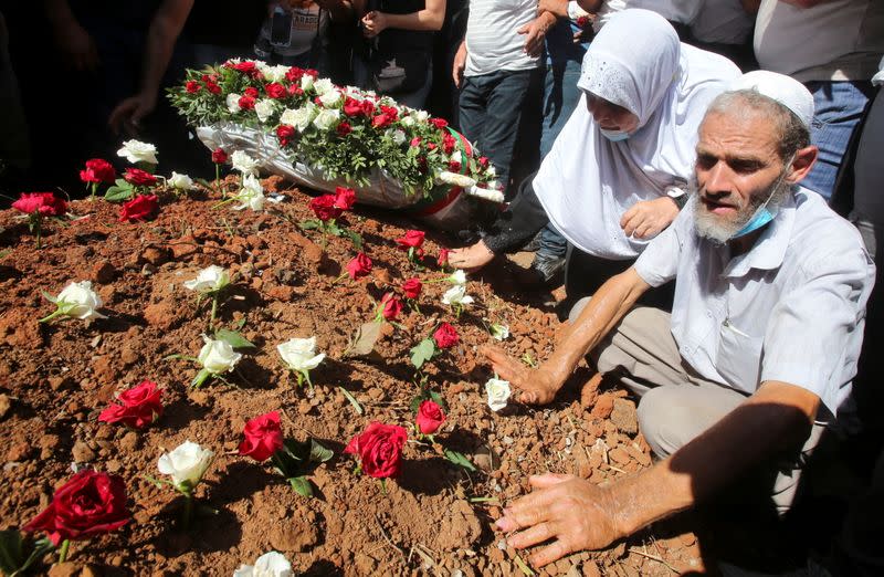 People put roses at the burial site of former Algerian President Abdelaziz Bouteflika at El Alia cemetery, in Algiers