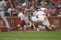 Cincinnati Reds' TJ Friedl is tagged out by St. Louis Cardinals catcher Yadier Molina while trying to steal home during the third inning of a baseball game Thursday, Sept. 15, 2022, in St. Louis. (AP Photo/Joe Puetz)