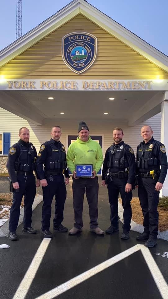 A man who saved York police officer Jonathan Rogers from being hit by a car in October was awarded a plaque of appreciation Wednesday, Dec. 22, 2021 in York, Maine.