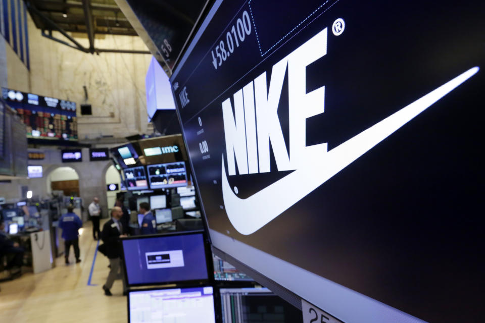 FILE - In this March 22, 2017, file photo, the Nike logo appears above the post where it trades on the floor of the New York Stock Exchange. Nike lost $790 million in the fourth quarter, as soaring digital sales couldn’t make up for the loss of revenue from shuttered stores in most of the world. The world’s largest sports apparel maker said Thursday, June 25, 2020, that its revenue fell 38% to $6.3 billion in the three-month period ending May 31. (AP Photo/Richard Drew, File)