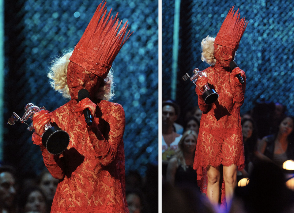 lady gaga's face covered speaking into a mic on stage