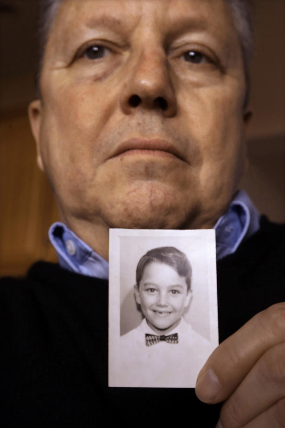Joe Iacono, 62, who was abused in the early 1960s while he was a student at St. John Vianney Catholic School in North Lake, Ill., holds a photo of him taken in 1960 when he was 9-years-old, while talking about The Archdiocese of Chicago releasing thousands of pages documenting clergy sex abuse allegations to victims' attorneys who have for years fought to hold the Catholic Church accountable for its handling of such claims, at his home Wednesday, Jan. 15, 2014, in Springfield, Ill. (AP Photo/Seth Perlman)