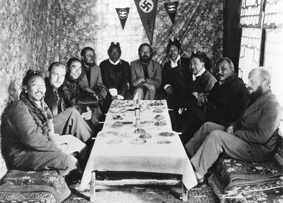 chaefer, Ernst *1912-1992+Zoólogo, Jefe de la SS-Tibet-expedición, 'SS-Científico' nombrado Sturmführer honorario en 1934.- con tibetanos en un banquete en Lhasa, 1939.en el centro E.Schaefer, a su lado (l) Tsarong Dzasa, 2º desde la izquierda Bruno Beger, 4º desde la izquierda Edmund Geer (ambos antropólogos), a la derecha Karl Wienert junto al Möndro tibetano.