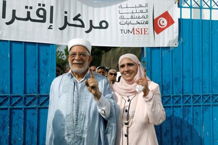 Abdelfattah Mourou, vice president of the moderate Islamist Ennahda party and presidential candidate, stands with his wife as they show their ink-stained fingers after casting their vote at a polling station during presidential election in Tunis