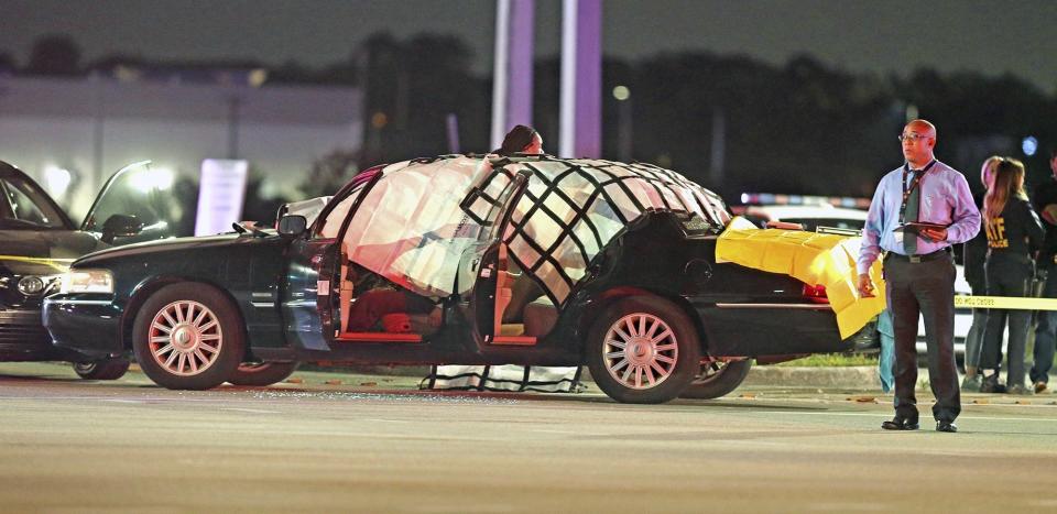 Law enforcement stand near a vehicle at the crime scene where four people were killed, Thursday, Dec. 5, 2019 in Miramar, Fla. The FBI says four people, including a UPS driver, were killed after robbers stole the driver's truck and led police on a chase that ended in gunfire at a busy Florida intersection during rush hour. (Charles Trainor Jr./Miami Herald via AP)