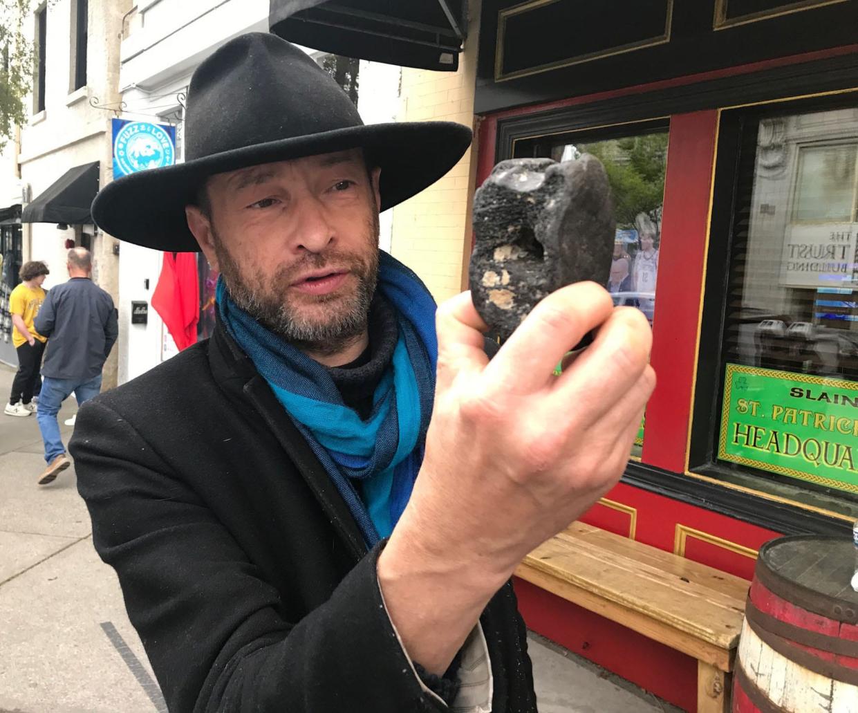 Misha Sobol, co-owner of the Slainte Irish pub in downtown Wilmington, with a fossil he found on Wrightsville Beach. The find might be millions of years old.