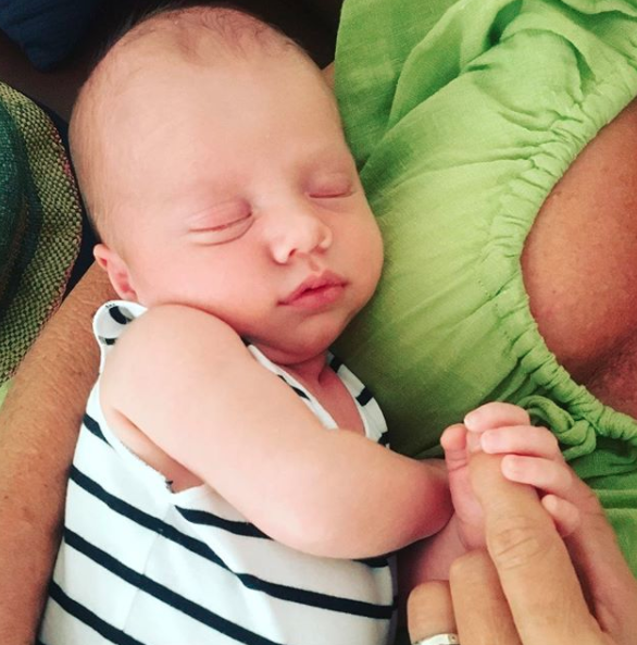 One adorable photo shows the 55-year-old cradling her new grandson, looking totally peaceful in his grandma's arms. Source: Instagram / lisacurry