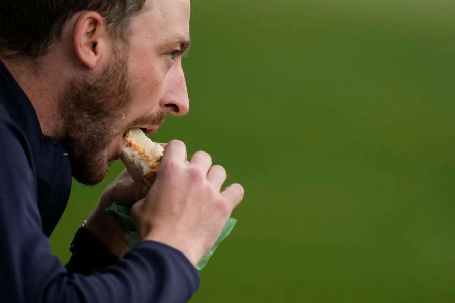 A patron eats a pimento cheese sandwich during a practice round in preparation for the Masters golf tournament at Augusta National Golf Club Tuesday, April 9, 2024, in Augusta, Ga. (AP Photo/Charlie Riedel)