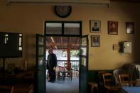 A man stands at the entrance of a coffee shop in Kormakitis village
