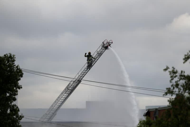 A firefighter is seen in a ladder while putting out a fire in a store in the aftermath of a protest in Minneapolis