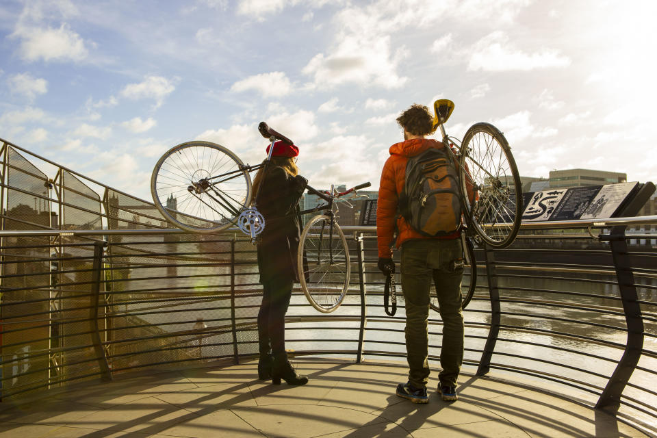 A couple carrying bicycles their shoulders by London Bridge during the Covid-19 lockdown in London. (Photo by Pietro Recchia / SOPA Images/Sipa USA)