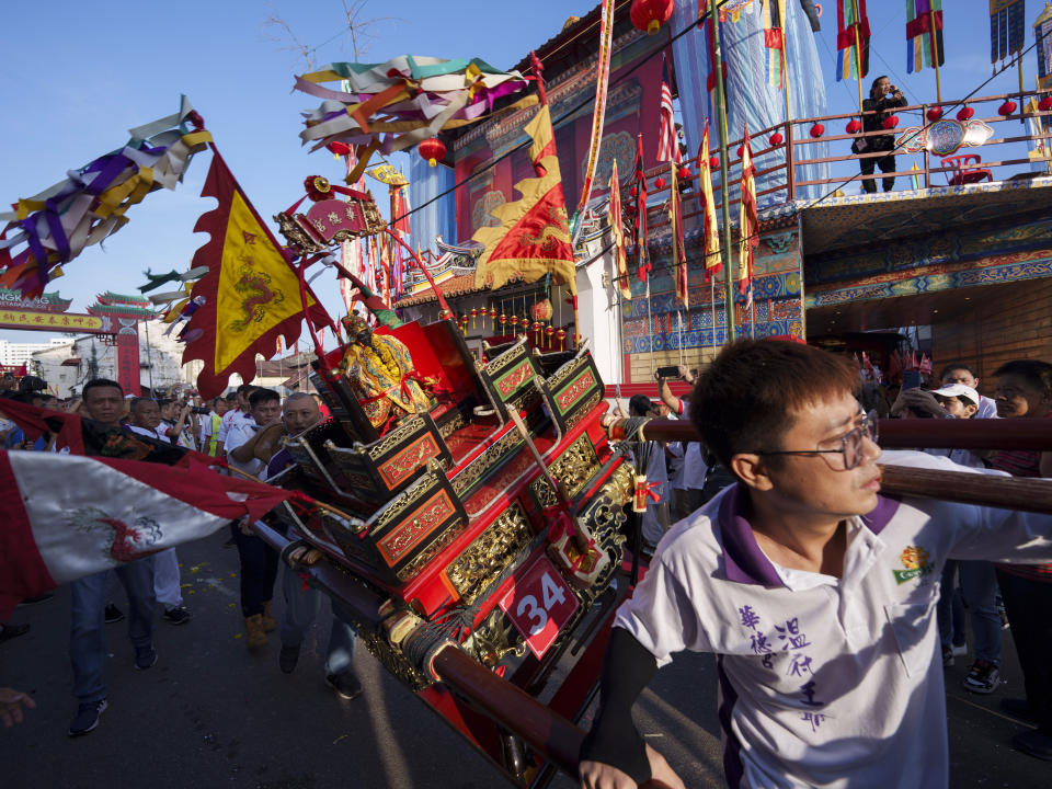Ethnic Chinese devotees carrying a sedan chair begin their 9 km procession during Wangkang or "royal ship" festival at Yong Chuan Tian Temple in Malacca, Malaysia, Thursday, Jan. 11, 2024. The Wangkang festival was brought to Malacca by Hokkien traders from China and first took place in 1854. Processions have been held in 1919, 1933, 2001, 2012 and 2021. (AP Photo/Vincent Thian)