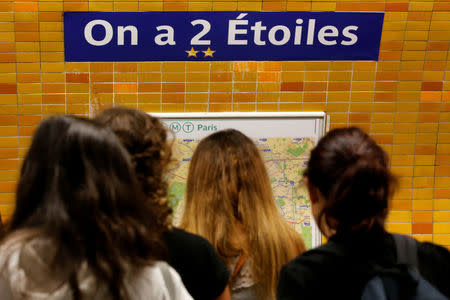 Foto del lunes de un grupo de pasajeros viendo el mapa de la red de metro de París en la estación "Charles de Gaulle - Etoile" rebautizada como "On a 2 Etoiles" tras la obtención de la Copa del Mundo en Rusia. Jul 16, 2018. REUTERS/Jean-Paul Pelissier