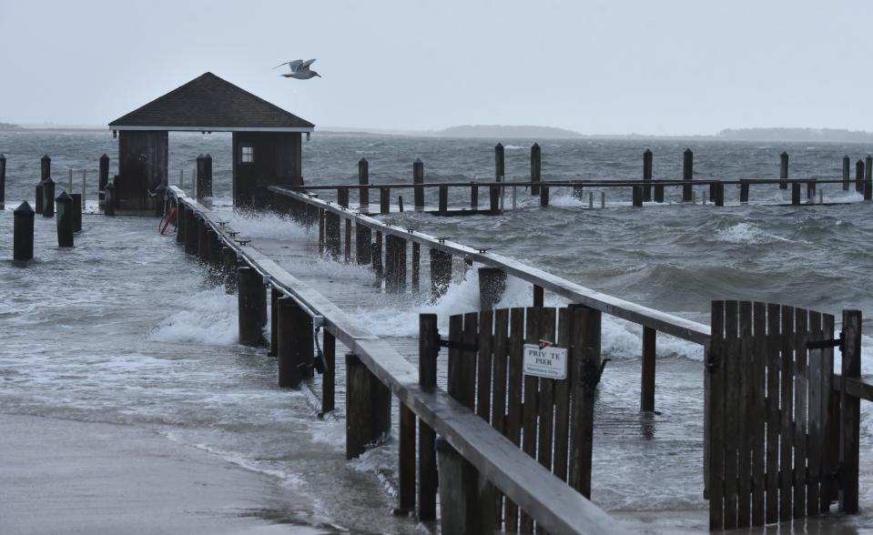 Storm-driven southerly winds flood over the Hyannisport Yacht Club dock Friday morning as high tide approaches during Winter Storm Elliott.