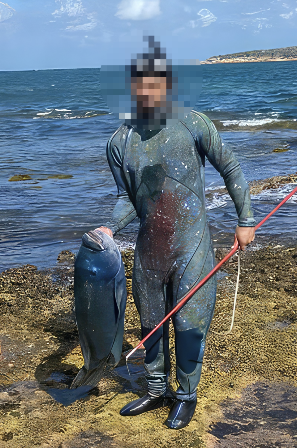 The spear fisherman holding up Gus the blue groper after killing the fish in Cronulla on Saturday. 