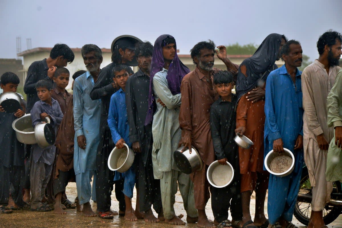 Evacuated people wait for food at a camp Sujawal, southern Pakistan (AP)