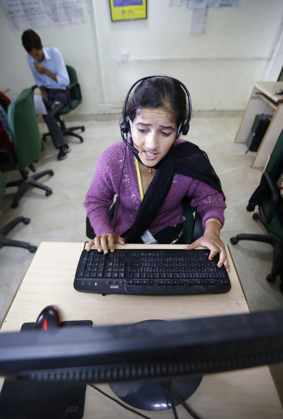 In this Aug. 23, 2012 photo, an employee talks to a client while working at the B2R center in Simayal, India. Before B2R arrived in Simayal, local women had little option but to marry right out of school, and educated young men had to travel far to seek respectable jobs. (AP Photo/Saurabh Das)