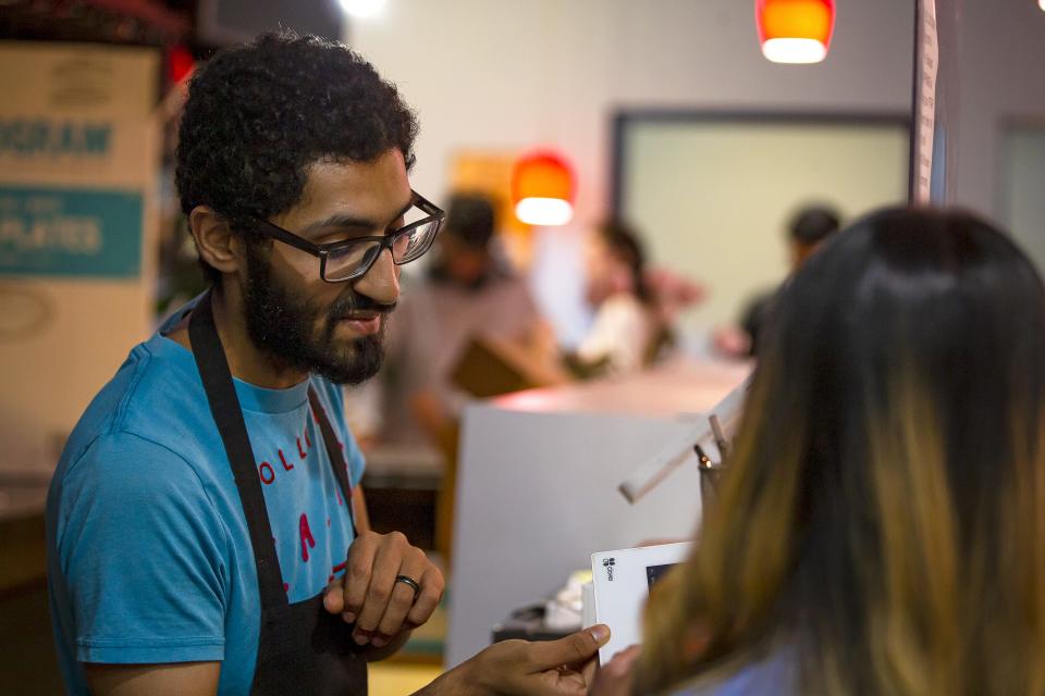 Abrahim Saleh assists a customer with a take-out meal from the iftar buffet at Mandi House in Tempe on April 25, 2022.