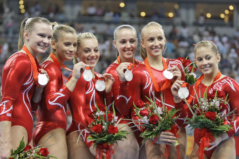 FILE - U.S. gymnasts, from left: Bridget Sloan, Alicia Sacramone, Samantha Peszek, Chellsie Memmel, Nastia Liukin, and Shawn Johnson pose with their silver medals after the women's team final competition at the Beijing 2008 Olympics in Beijing, in this Aug 13, 2008, file photo. Memmel started doing gymnastics again when the COVID-19 pandemic hit last spring because it felt like one of the few things in her life she could control. The 32-year-old former world champion and Olympic silver medalist discovered more than an outlet for stress. She rediscovered her love for the sport, so much so the married mother of two is making an unlikely comeback.(AP Photo/Amy Sancetta, File)