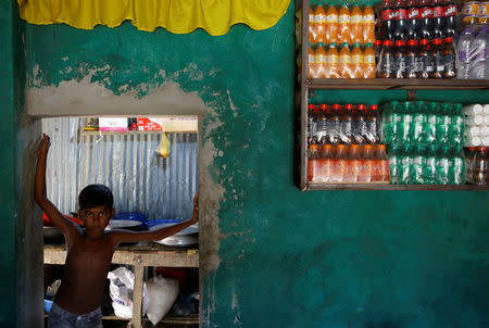 Azimul Hasan, 10, a Rohingya refugee boy, stands by a door of a roadside hotel where he works at Jamtoli, close to Palong Khali camp, near Cox's Bazar, Bangladesh, November 12, 2017. REUTERS/Navesh Chitrakar