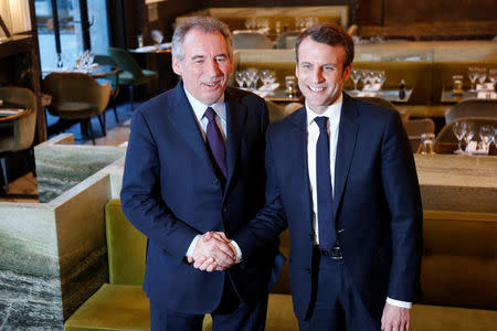 Emmanuel Macron, (R) head of the political movement En Marche !, or Onwards !, candidate for the 2017 presidential election, and Francois Bayrou, French centrist politician and the leader of the Democratic Movement (MoDem), arrive for a news conference after sealing their alliance for the presidential campaign, in Paris, France, February 23, 2017. REUTERS/Charles Platiau