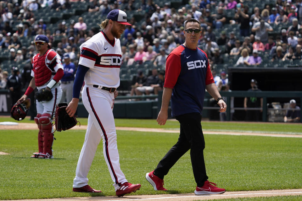 Chicago White Sox starting pitcher Michael Kopech, front left, walks to the dugout with a team trainer after being injured during the first inning of a baseball game against the Texas Rangers in Chicago, Sunday, June 12, 2022. (AP Photo/Nam Y. Huh)