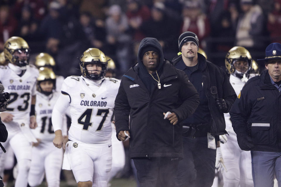 Colorado coach Deion Sanders, center, runs out with the team before an NCAA college football game against Washington State, Friday, Nov. 17, 2023, in Pullman, Wash. (AP Photo/Young Kwak)