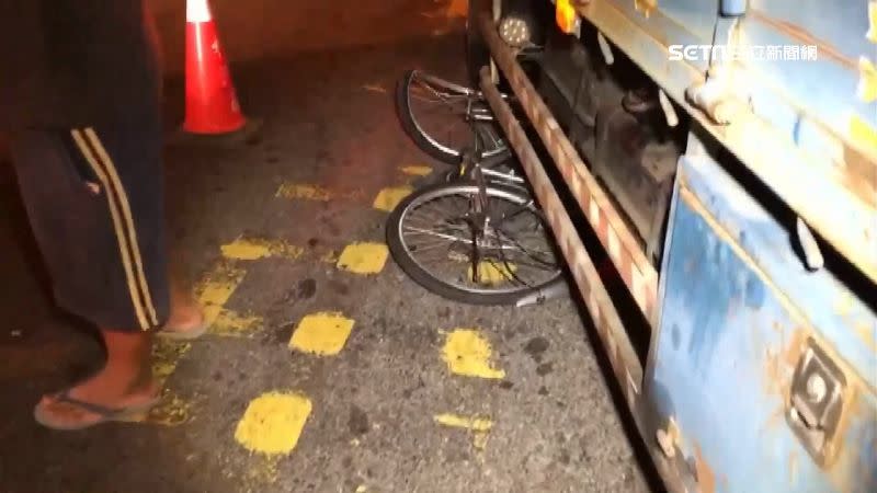 單車卡在貨車輪胎下。