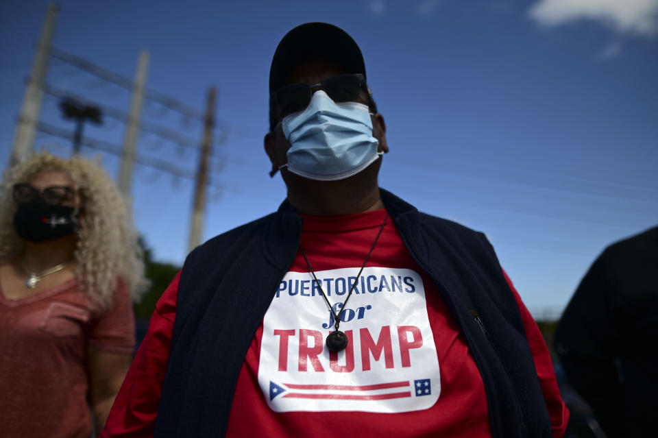 Supporters of president Donald Trump gather moments before leaving for the headquarters of the Republican party in support of his candidacy a few weeks before the presidential election next November, in Carolina, Puerto Rico, Sunday, Oct. 18, 2020. President Donald Trump and former Vice President Joe Biden are targeting Puerto Rico in a way never seen before to gather the attention of tens of thousands of potential voters in the battleground state of Florida. (AP Photo/Carlos Giusti)