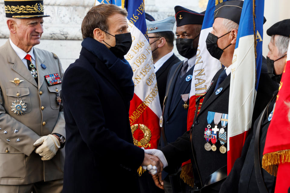 French President Emmanuel Macron meets veterans under the Arc de Triomphe during ceremonies marking the 103rd anniversary of Armistice Day, Thursday, Nov. 11, 2021 in Paris. (Ludovic Marin, Pool via AP)