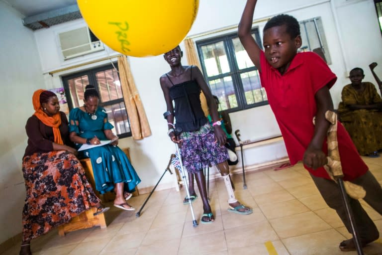 Nyakuatch Met (C), 14, and Kan Chol (R), 5, from Bentiu, South Sudan, both lost their left legs while fleeing their village due to the fighting