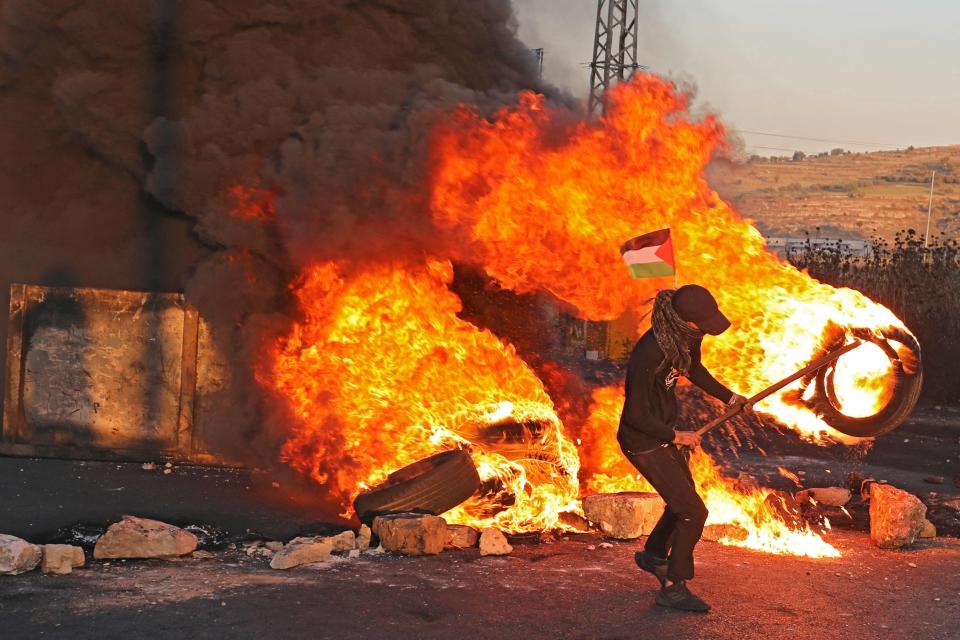 Palestinian demonstrators burn tyres during a protest against the tension in Jerusalem and the Israeli-Gaza fighting (AFP via Getty Images)