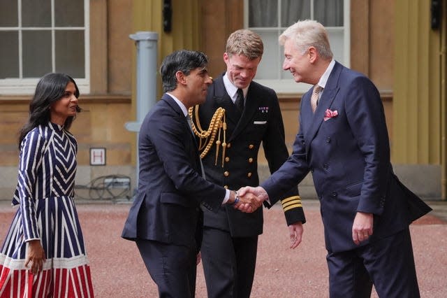Rishi Sunak and his wife are greeted at Buckingham Palace