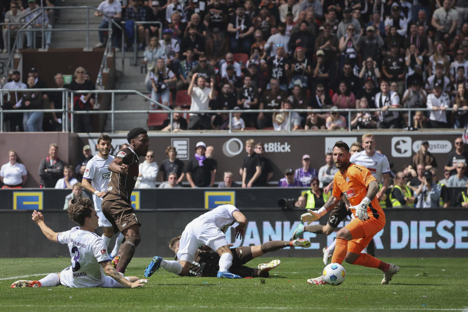 St. Pauli's Oladapo Afolayan, third from left, scores his side's opening goal, during a second division, Bundesliga soccer match between St. Pauli and VfL Osnabrück, at the Millerntor Stadium, in Hamburg, Germany, Sunday, May 12, 2024. (Axel Heimken/dpa via AP)