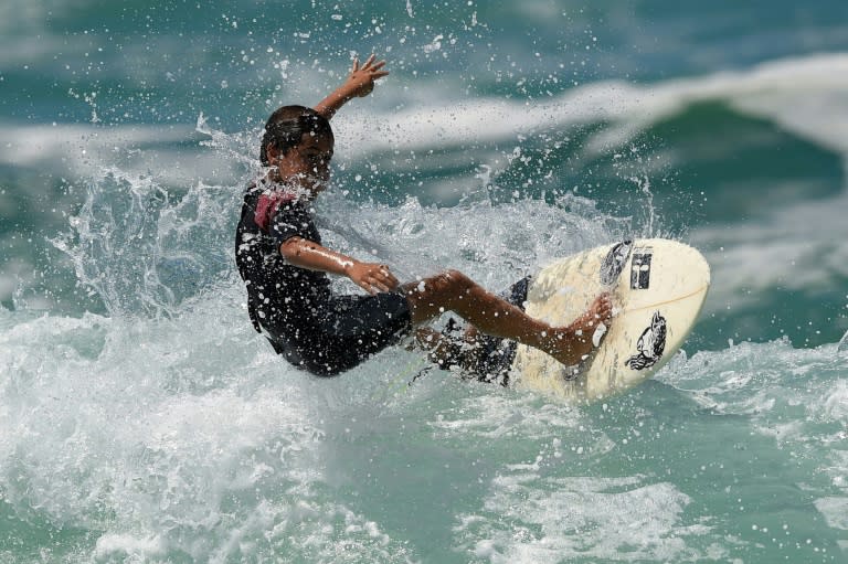 Young surfer Rickson Falcao, 10, rides a wave at Saquarema's beach in Rio de Janeiro state, Brazil, on November 29, 2017