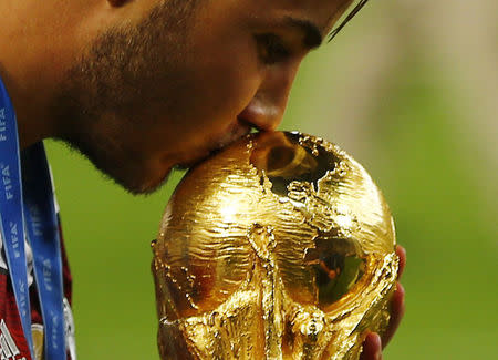 Germany's Mario Goetze kisses the World Cup trophy as he celebrates their 2014 World Cup final win against Argentina at the Maracana stadium in Rio de Janeiro July 13, 2014. REUTERS/Damir Sagolj