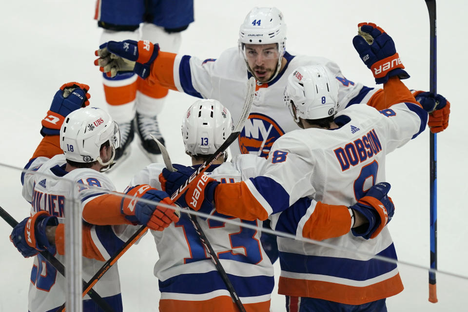 New York Islanders center Jean-Gabriel Pageau (44), left wing Anthony Beauvillier (18) and defenseman Noah Dobson (8) join to celebrate a goal scored by center Mathew Barzal (13) during the first period of Game 5 against the Boston Bruins during an NHL hockey second-round playoff series, Monday, June 7, 2021, in Boston. (AP Photo/Elise Amendola)